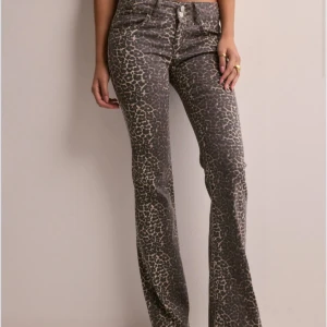 Leopardmönstrade bootcut jeans lågmidjade  - Snygga jeans med leopardmönster och bootcut-passform. Byxorna har låg midja, klassiska fickor och stängs med dragkedja och knapp. Perfekta för dig som vill sticka ut med ett djurmönster i garderoben., använd ett fåtal gånger, slutsålda i 38