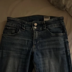 Blå bootcut jeans från H&M - Säljer ett par klassiska blå bootcut jeans från H&M med låg midja och justerbar midja. Storlek 164 är använda men är inget hål eller nått i dom så de ser nya ut. Pris går att diskutera!