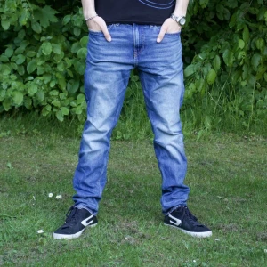 Blå jeansbyxor herr - Klassiska blå jeansbyxor med normal passform och raka ben. Byxorna har fem fickor, dragkedja och knapp i midjan. Perfekta för en avslappnad stil och funkar året runt.