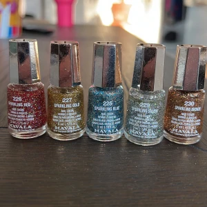 Glittriga nagellack från Mavala i fem färger - Fem nagellack från Mavala i färgerna Sparkling Red, Sparkling Gold, Sparkling Blue, Sparkling Silver och Sparkling Bronze. Alla lack har mycket glitter och kommer i små glasflaskor med silverfärgat lock. Perfekt för att skapa festliga naglar med extra lyster.