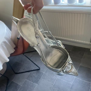 Silvriga klackskor  - Snygga klackskor med en liten klack och spetsig tå (är lite slitas på tårna,se bild 2 men inget märkbart vid användning)🪩slutsålda på hemsidan. klackhöjd 6cm. Nypris 599kr passar 40/41