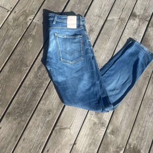 Blå jeansbyxor med raka ben - Säljer ett par klassiska blå jeans med raka ben och femficksmodell. Jeansen har normal passform och är tillverkade i denim med lätt slitning framtill. Perfekta för en avslappnad stil.