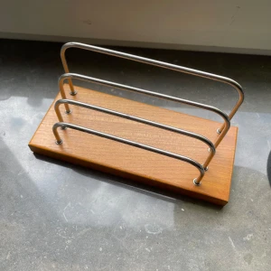 Bokställ i trä och metall - Snyggt bokställ med bas i ljust trä och tre bågar i silverfärgad metall. Perfekt för att organisera böcker eller tidningar på skrivbordet eller i bokhyllan. Enkel och stilren design som passar i de flesta hem.