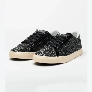 Svarta glittriga sneakers  - Säljer ett par svarta sneakers med glittrig ovandel och svarta detaljer. Skorna har vit sula, svarta skosnören och en stjärndetalj på sidan. 
