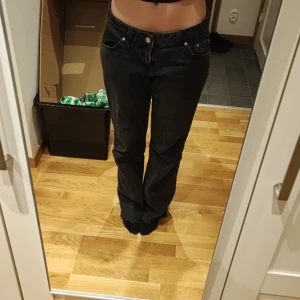 Svarta Perfect Jeans från Gina Tricot - Säljer ett par svarta Perfect Jeans från Gina Tricot. Byxorna har normal passform med raka ben och klassisk femficksdesign. De är tillverkade i jeansmaterial och har knapp- och dragkedjestängning framtill.