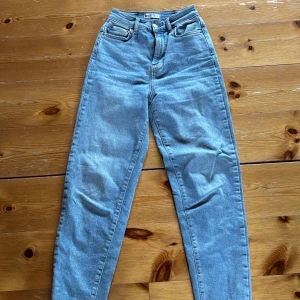 Ljusblå jeansbyxor från ginatricot - Säljer ett par ljusblå jeansbyxor från ginatricot. Byxorna har hög midja, klassisk femficksdesign och raka ben. Perfekta för dig som gillar en tidlös och enkel stil.
