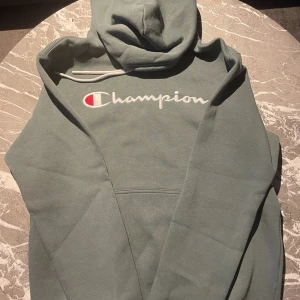 Champion Hoodie - Snygg och enkelt hoodie från märket Champion. Hoddien är endast använd 3-4 gånger och är nyskick. Ny pris ligger på ca 550 kr. Om du har några frågor kring produkten eller priset så är de bara att höra av dig.😄  Mvh Stockholm Wardrobe 