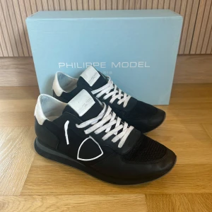 Philppe model TRPX trainers - Säljer ett par svarta Philippe Model trainers med vita detaljer och snörning. Perfekta för dig som gillar stilrena och bekväma sneakers. Ny pris ca 3000kr. Snygga och passar till allt. Använda fåtal gånger så mycket bra skick. Hör av dig vid frågor