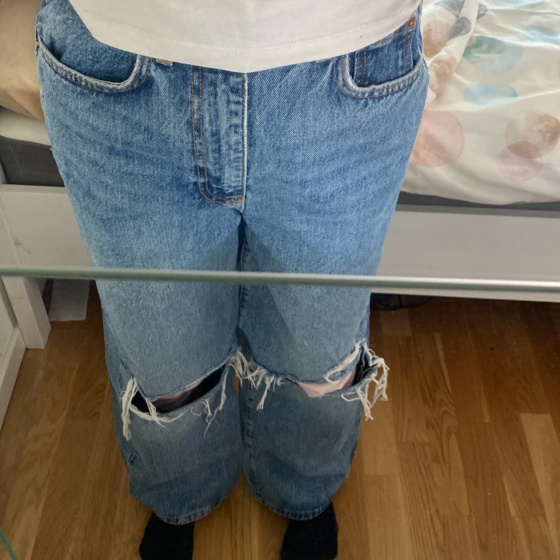 Blå jeans med hål på knäna
