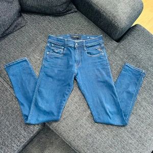 Blå Replay Anbass jeans - Säljer ett par blå Replay Anbass jeans i modellen Hyperflex. Jeansen har klassisk femficksdesign, normal passform och raka ben. Perfekta för dig som vill ha bekväma och stilrena jeans till vardags.