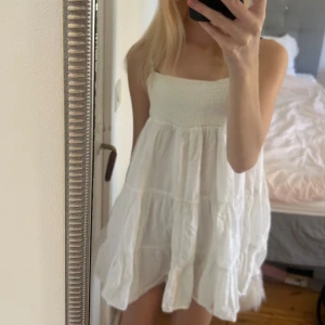 Vit kort klänning med volang - Säljer en söt vit kort klänning med volang. Från Zara i storlek Xs💕