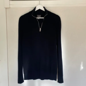Svart stickad tröja med dragkedja  - Svart stickad tröja med 1/4 zip från H&M. Storlek S, slim fit. Tröjan är välanvänd men fortfarande i ett fint skick. 