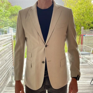 Beige kavaj från j.lindeberg - Kavajen är oanvänd, och helt nytt skick. Bra kvalitet. Över 5000kr ny, mitt pris endast 1500kr!!!  