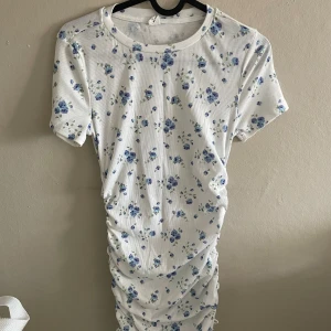 Vit blommig klänning - En vit blommig klänning från shein. Klänningen är lite genomskinlig men följer med ett längre linne man kan ha under. Väldigt somrig och passar bra till varma dagar.