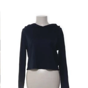 Mörkblå croppad hoodie - Säljer en mörkblå croppad hoodie med långa ärmar och huva. Perfekt för en avslappnad stil och enkel att matcha med andra plagg. Mjuk och skön att ha på sig. Från hollister!🙌🥹