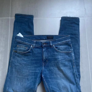Tiger of Sweden jeans  - Säljer ett par blå Tiger of Sweden jeans  med normal passform och raka ben. Byxorna har klassisk femficksdesign, knappgylf och orangea sömmar. Perfekta till vardags och passar till det messta. Kan gå ner i pris vid snabb affär.💨