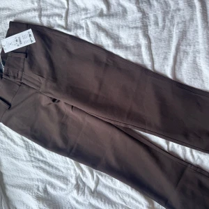 Bruna kostymbyxor från Gina Tricot - Säljer bruna kostymbyxor från Gina Tricot i bootcut modell. Det är helt nya med prislappen på. Det är helt oanvända eftersom det är för långa på mig, skriv privat för fler bilder💗
