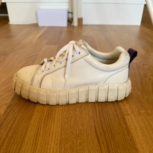 Chunky sneakers från Eytys - Säljer ett par chunky vita sneakers från Eytys i storlek 42. Skorna har en kraftig, räfflad sula och är gjorda i skinn. Trots sina nya vita snören så är dem välanvända och väldigt slitna. Dem behöver helt enkelt lite kärlek, därav priset. Kommer med originalpåse och kartong.