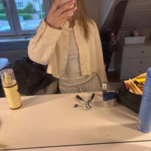 Beige croppad skjorta från Divided - Säljer en beige croppad skjorta från Divided i manchestertyg. Skjortan har långa ärmar, klassisk krage och knäppning framtill. Perfekt för dig som gillar en chill och trendig stil. Passar snyggt till både jeans och mjukisbyxor.