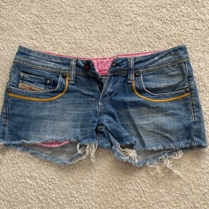 Diesel jeansshorts med brodyr - blå jeansshorts ifrån diesel, rosa kant inuti och gul brodyr på fickorna ❣️ Finns inte att hitta eftersom dom inte säljs längre. ❤️ Har inte heller används så mycket så dom är i super bra skick 🥰