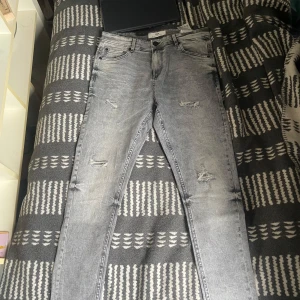 Grå slitna tapered jeans från FSBN - Säljer ett par grå jeans från FSBN (new yorker)  dom är aldrig använda och bara ligger o tar plats.  Storlek W31 L30 