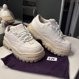 Chunky vita sneakers från Eytys - Säljer ett par chunky vita sneakers från Eytys med kraftig plattformssula och grovt mönstrad yttersula. Skorna har snörning, detaljer i lila baktill och är tillverkade i skinn med robust gummisul💕