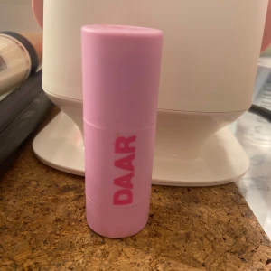 DAAR blush stick Coral Crush - Krämrouge i stickformat från DAAR i färgen Coral Crush. Kommer i en söt ljusrosa hylsa med rosa text. Perfekt för att ge kinderna en fräsch, korallfärgad glow. Enkel att applicera direkt på huden och smidigt att ta med i väskan.