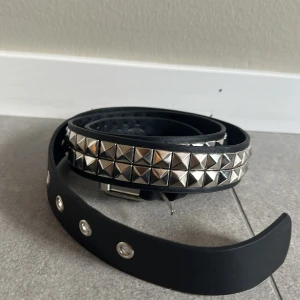Svart nitarbälte med silverdetaljer - Snyggt svart bälte med silvriga nitar. Så snyggt till ett par low waist jeans eller baggy🌟 längd ca 108 cm
