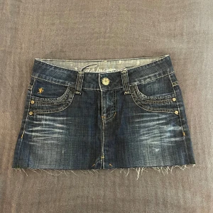 Mörkblå lågmidjad jeanskjol  - Skitsnygg mörkblå och lågmidjad jeanskjol från Esprit. Den har knappar på bakfickorna, sitter jätteskönt och är i storlek S. Perfekt för sommaren! Jag är utomlands så reserverar kjolen till den första som vill köpa! Postar när jag kommer hem, 14 juli. 