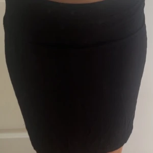 Svart tight kortkjol - Enkel och stilren svart kortkjol med tight passform. 