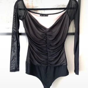 Helt ny body strl S från NLY trend (Nelly) - Den här bodyn är aldrig använd pga fel storlek. Den har genomskinliga ärmar och ett mycket smickrande dekolletage. Bild på knäppning i grenen så man kan se att den verkligen är oanvänd. Den är strl S och kommer från NLY ONE, Nelly. Katter finns i hemmet