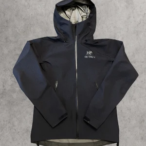 Äkta Arcteryx beta LT jacka  - Ny arcteryx beta LT jacka som bara använts ett fåtal gånger. Köpt på Naturkompaniet för ca 5499 kr, lapparna finns kvar (sitter inte på jackan), inga hål eller fläckar. Jackan är gjord i Gore-Tex, perfekt för regn och vind. Jackans färg är black sapphire.