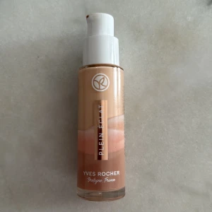 Yves Rocher Plein Éclat Foundation - Flytande foundation från Yves Rocher i nyansen Plein Éclat. Kommer i en glasflaska med pump och rymmer 30 ml. Färgen är en varm beige ton som ger en naturlig finish. Perfekt för dig som vill ha en jämn och fräsch bas.