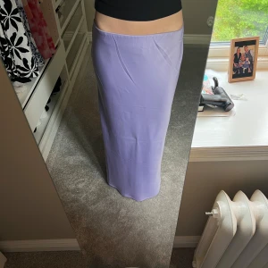 Ljuslila långkjol från Gina Tricot - Supersnygg ljuslila långkjol från Gina Tricot som är slät och glansig . Kjolen har en rak passform, perfekt för dig som vill ha en clean och stilren look. 