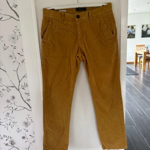 Mustardgula manchesterbyxor Jack & Jones - Säljer min pappas mustardgula manchesterbyxor från Jack & Jones i regular fit. Byxorna har klassisk design med fickor fram och bak, bälteshällor och stängs med knapp och dragkedja. Midjemåttet: 45-46cm rakt över. Innerbenslängd:74-75cm. Läs gärna bio😊