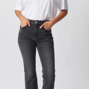 Mörkgråa raka jeans med rå kant - Säljer ett par mörkgråa jeans med raka ben. Jeansen har en snygg rå kant nertill och klassisk femficksdesign. Perfekta till sneakers eller klackar för en cool look. Aldrig använda köptes för 500kr men säljer för 150kr vid intresse kan fler bilder skickas.