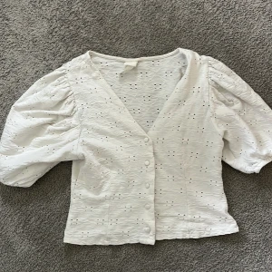 Vit blus med puffärm från H&M - Supersöt vit blus från H&M med puffiga ärmar och v-ringning. Det finns lite defekter (se sista bilderna) men det syns inte när man har på den💕Samt finns det lite ”lösa” trådar men det kan man klippa bort!!