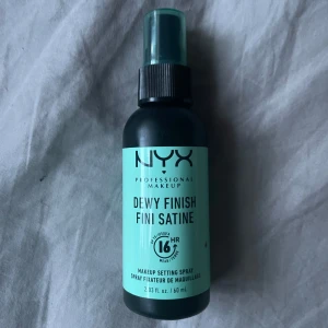 NYX Setting Spray - Makeup setting spray från NYX som ger en daggfräsch finish och håller sminket på plats i upp till 16 timmar. Kommer i en svart plastflaska med spraymunstycke och turkos etikett. Innehåller 60 ml. Oanvänd.