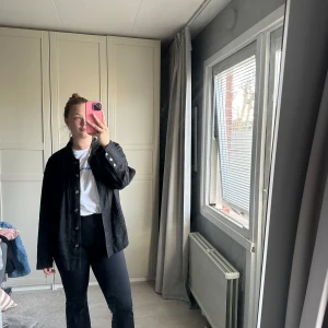 Svart linnejacka från XLNT Woman (Kappahl) - Säljer en svart linnejacka från XLNT Woman (Kappahl) i storlek XL(48). Jackan har klassisk krage, knäppning framtill med silverfärgade knappar och långa ärmar. Perfekt att slänga över en t-shirt för en avslappnad look. 100% Linen