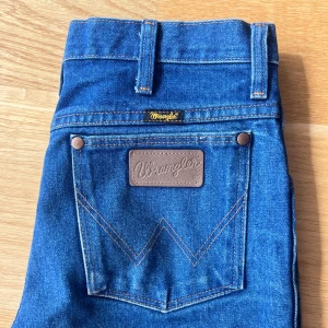 Wrangler jeans mörkblå - Mörkblå Wrangler jeans i bra kvalitet, uppskattningsvis storlek M. Innerben 81 cm, midja ca 78 cm runt. Bra skicka, inga slitningar någonstans, endast minimal blekning längst ner på benet. 