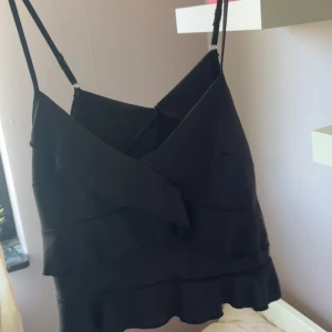 Svart volangig linnetopp från SHEIN - Säljer en svart linnetopp från SHEIN med volanger. Aldrig använd. Storlek S. Skriv vid frågor 