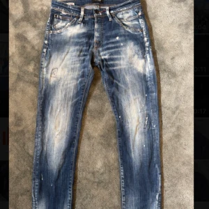 Jack and Jones jeans (limited edition) slim glenn - Säljer ett par blå jeansbyxor från Diesel med slitna detaljer och ljusa partier framtill och baktill. Byxorna har klassisk femficksdesign, knappgylf och raka ben. Perfekta för en avslappnad och trendig look. W29 L32
