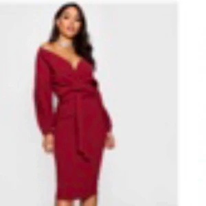 Vinröd omlottklänning från Boohoo Night - Säljer en vinröd omlottklänning från Boohoo Night med v-ringning och långa puffärmar. Klänningen har ett knytband i midjan och är knälång, perfekt för dig som vill ha en elegant och stilren look.