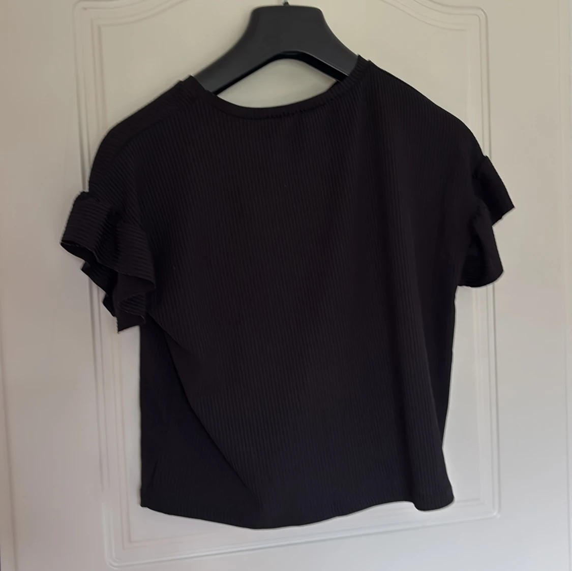 Svart ribbad topp med volangärmar - 1