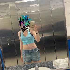 Blå jeansshorts från Divided H&M - Säljer ett par blå jeansshorts från H&M jag hade i Florida. Den har stora fickor framtill och elastisk midja. Perfekta för varma dagar och enkel att matcha med olika toppar. Den blåa toppen säljs i en annan annons🩵