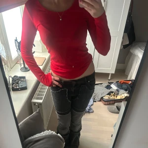 Röd långärmad tröja  - Säljer en röd långärmad tröja med tight passform. Tröjan har en enkel design utan synliga mönster eller detaljer och är perfekt för dig som gillar en stilren look.