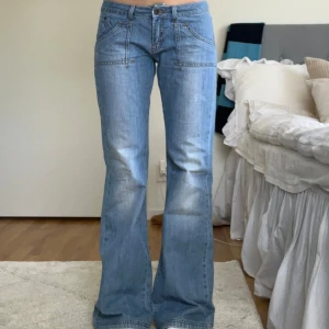 Lågmidjade utsvängda jeans - Snygga lågmidjade utsvängda jeans. Ljusblåa och i mycket bra skick, mått finns bland bilderna❣️