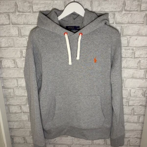 Ralph Lauren hoodie - Säljer en riktigt fräsch grå hoodie från Ralph Lauren! Mjuk, bekväm och i nyskick, med snygg broderad logga och vita dragsnören. Nypris ca 2300 kr – passa på att fynda, kan släppa billigare vid snabb affär. Hör av dig vid intresse! 🙌
