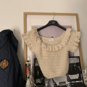 Beige stickad topp med volang från H&M - Söt beige stickad topp från H&M med bred volang runt halsringningen. Den är jätte skön, i lite tjockare matrial! Skriv om ni har frågor!❤️❤️❤️