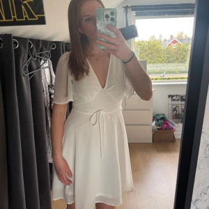 Vit v-ringad klänning - Säljer min fina vita klänning som jag köpte på Veromoda för 2 år sedan🤍 jag hade denna på min skolavslutning, den är så söt och väldigt skön i materialet! Nypris: 300kr